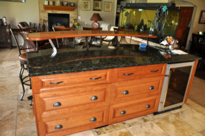 Photo of custom cherry wood kitchen cabinets and island at a home in Grand Junction